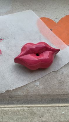 a pink vase sitting on top of a piece of paper next to a red heart