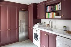 a kitchen with purple cabinets and a white washer and dryer in the corner