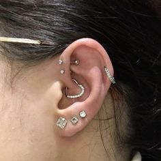 a woman wearing ear piercings with diamonds