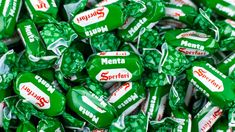 many green and white candy candies are stacked on top of each other, with the word menta printed on them