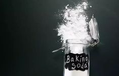 baking soda spilling out of a glass jar with a spoon sticking out of the top