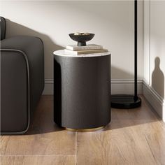 a black and white table sitting on top of a wooden floor next to a gray couch