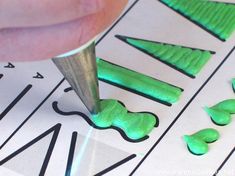 a person is cutting out letters with a sharpie pen on top of the paper