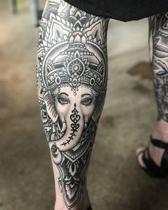 an elephant tattoo on the leg of a person's legs, with intricate designs