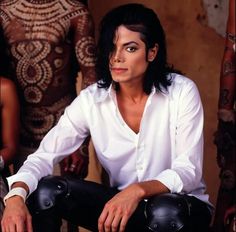 michael jackson sitting on a chair in front of two other people