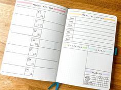 an open planner book sitting on top of a wooden table