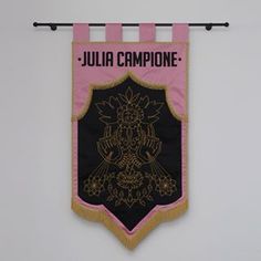 a pink and black banner hanging on a wall with the name julia campione