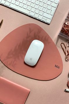 a mouse pad with a computer keyboard and other office supplies around it on a desk