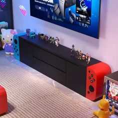 an entertainment center with video game controllers and toys on the floor in front of a television