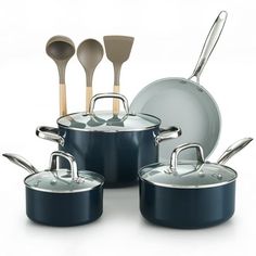 an assortment of pots and pans with wooden spoons in them on a white background