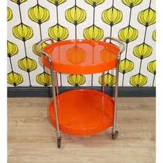 an orange two tiered serving cart with wheels