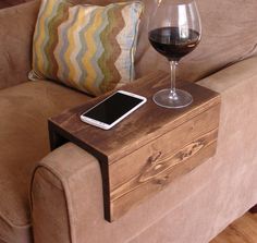 a glass of wine sitting on top of a wooden table next to a cell phone