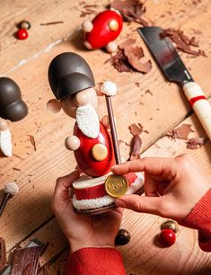 a person is holding a small figurine in front of some other items on the table