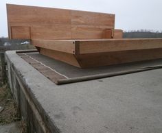 two wooden benches sitting on top of a cement slab