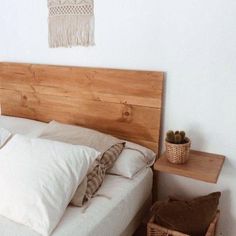 a bed with white linens and wooden headboard next to a wicker basket