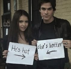 two people holding signs that say he's hot and she's rotten