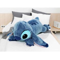 a blue stuffed animal laying on top of a bed