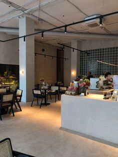 an empty restaurant with tables and chairs in the center, people are sitting at their desks