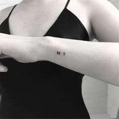 a woman's arm with the word m t tattooed on her left forearm and wrist