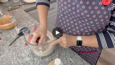 a woman mixing something in a glass bowl