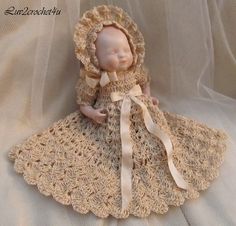 a crocheted doll is wearing a bonnet and dress