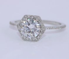 an engagement ring with a diamond center surrounded by pave diamonds