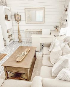 a living room filled with furniture and a wooden table in front of a white wall