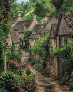 an old village with lots of houses and flowers on the side walk, surrounded by greenery