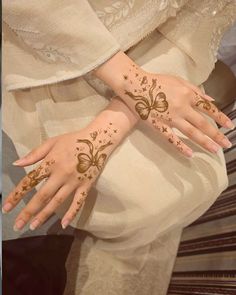 a woman's hands with henna tattoos on them