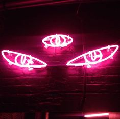 two neon lights that are on the side of a brick wall