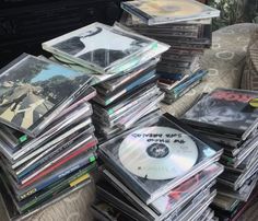 a pile of cds sitting on top of a table next to a couch and chair