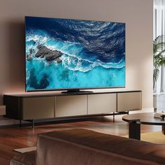 a flat screen tv sitting on top of a wooden entertainment center in a living room