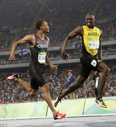 two men running on a track in front of an audience