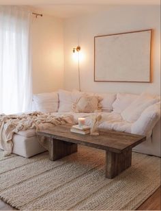 a living room with white furniture and pillows