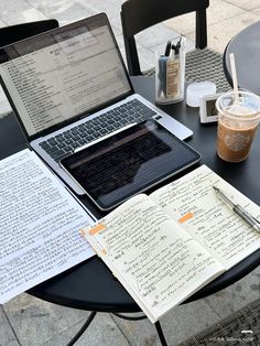 an open laptop computer sitting on top of a table next to a cup of coffee