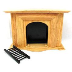 a small wooden fireplace with a black hearth and shelf next to it on a white background