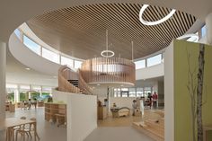 the interior of a children's playroom with wooden stairs and circular ceiling lights