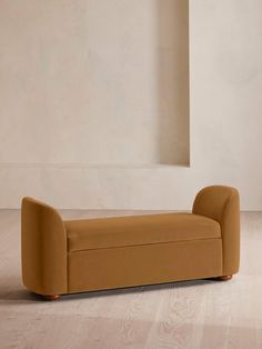 a couch sitting on top of a hard wood floor next to a white wall in an empty room