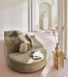 a large circular couch sitting on top of a hard wood floor next to a table