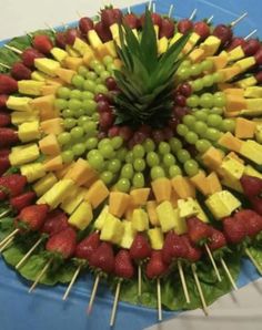 a platter filled with fruits and veggies arranged in the shape of a flower