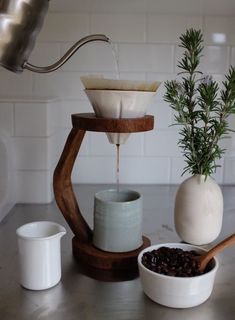 coffee being poured into a cup from a wooden spout on top of a counter