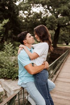 a man and woman embracing on a bridge