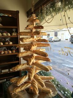 breads are stacked on top of each other in front of a storefront window