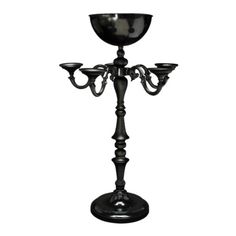 a black candle holder with three candles on it's sides and an ornate design in the middle