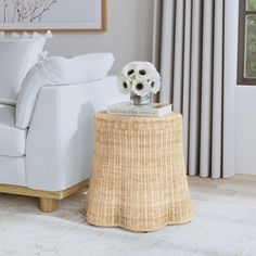 a living room with white furniture and flowers on the end table