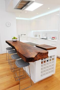 a kitchen with an island made out of wood and metal barstools in the center