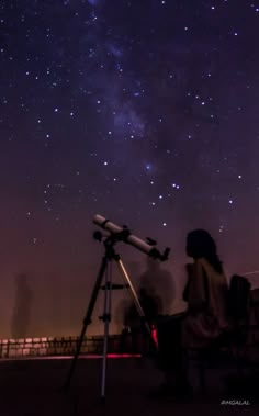 a person looking at the stars through a telescope