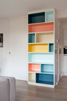 a living room filled with furniture and colorful shelves