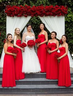 a group of women in red dresses standing next to each other