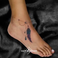 a woman's foot with a feather and beads tattoo on the side of her leg